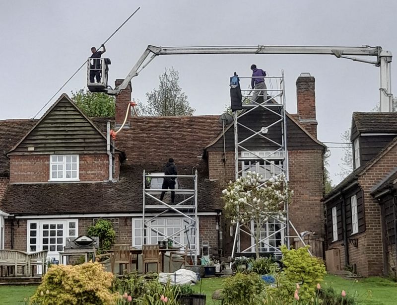 The Roof Moss Cleaners using cherry picker and scaffolding to clean roof safely and professionally in Redhill, Surrey